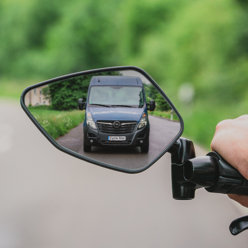 Bild eines Fahrradspiegels in dem sich ein blauer Kastenwagen spiegelt